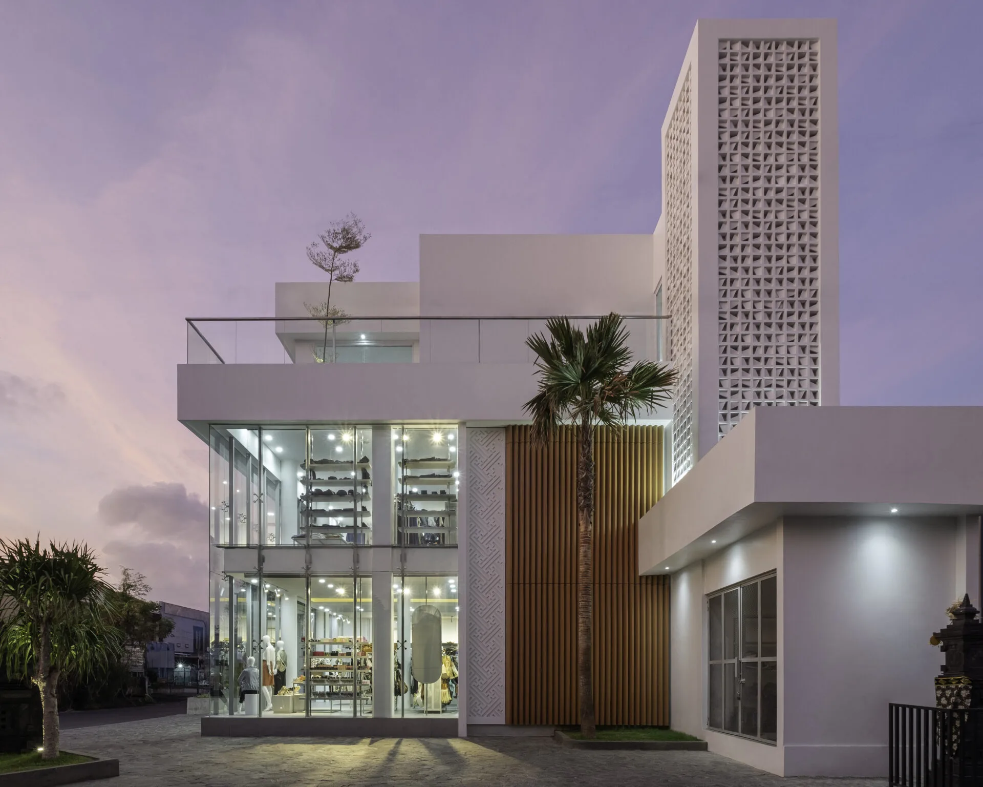 modern two-story glass-fronted retail building at dusk